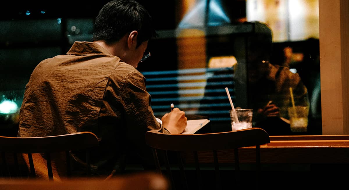 Man writing at coffee shop